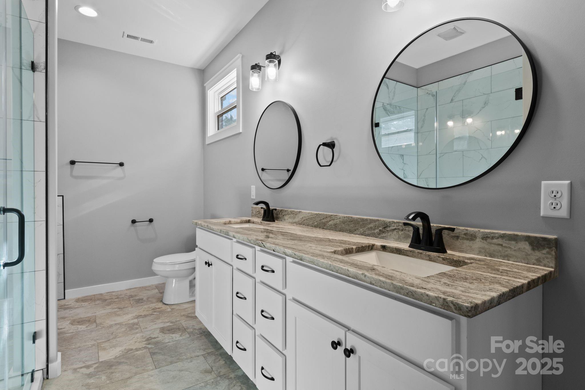 80 Peyton Elaine Road Clyde, NC 28721 - Photo 16 of 28 a bathroom with a granite countertop double vanity and a mirror