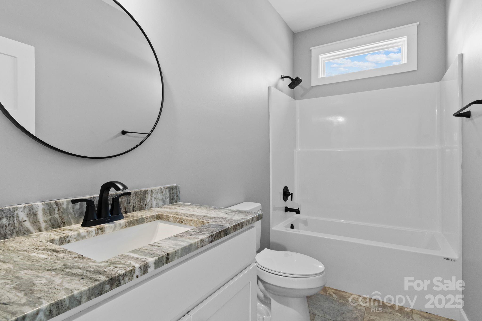 80 Peyton Elaine Road Clyde, NC 28721 - Photo 21 of 28 a bathroom with a granite countertop sink toilet and a mirror
