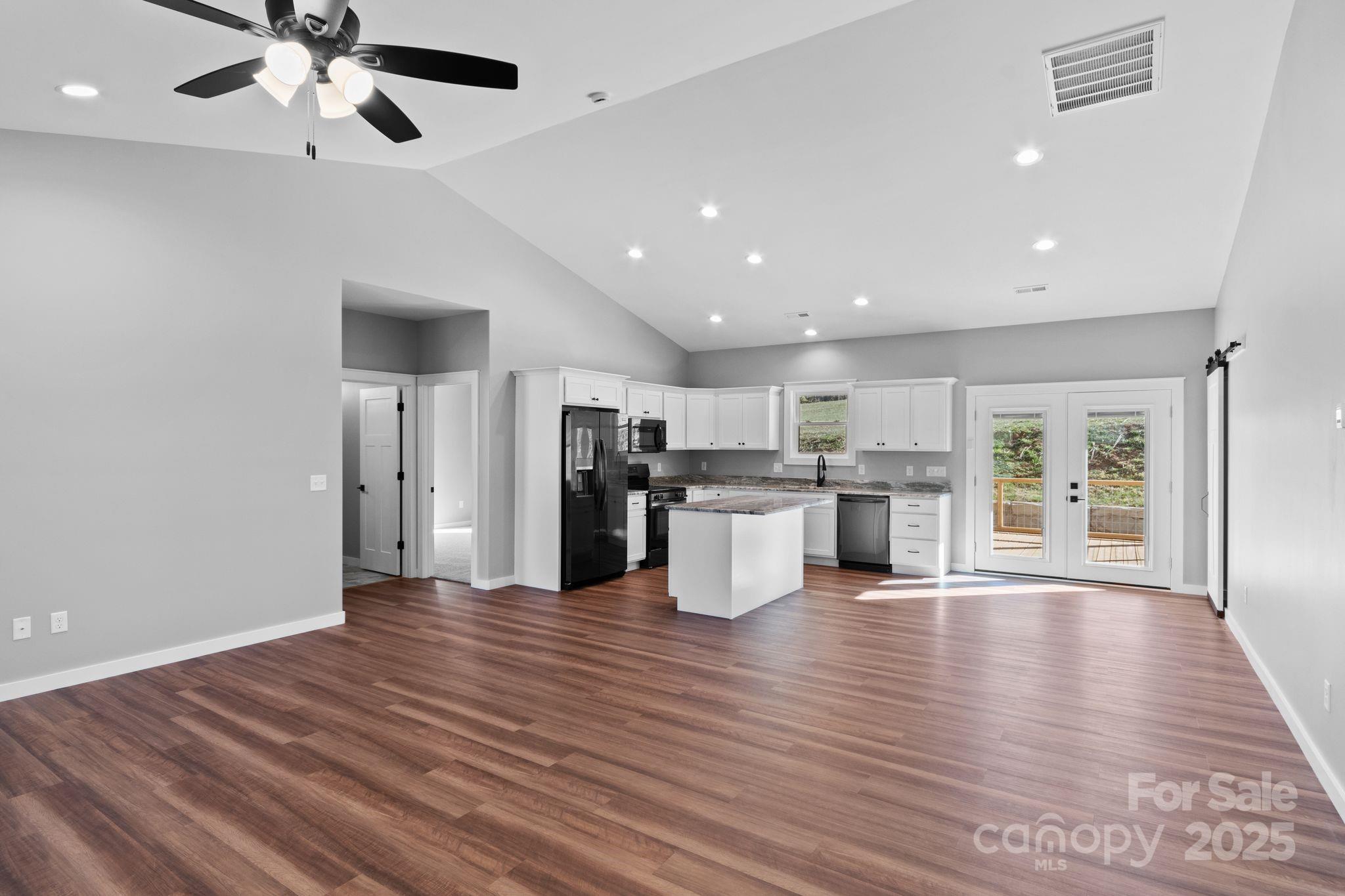 80 Peyton Elaine Road Clyde, NC 28721 - Photo 4 of 28 a view of an empty room and kitchen with wooden floor