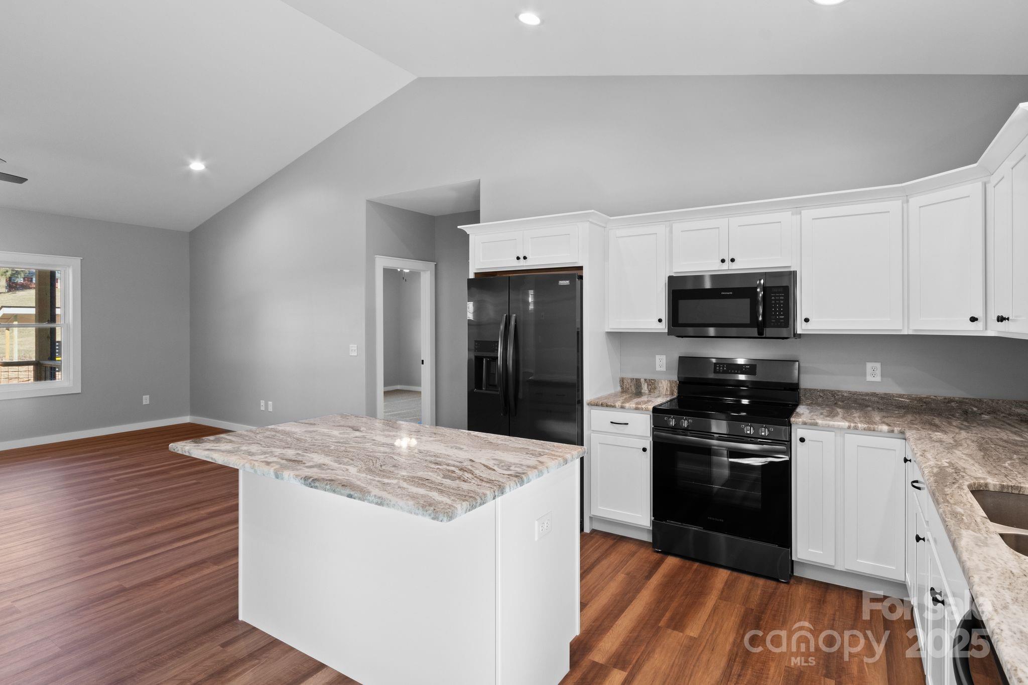 80 Peyton Elaine Road Clyde, NC 28721 - Photo 5 of 28 a kitchen with stainless steel appliances kitchen island granite countertop a stove a sink and a refrigerator