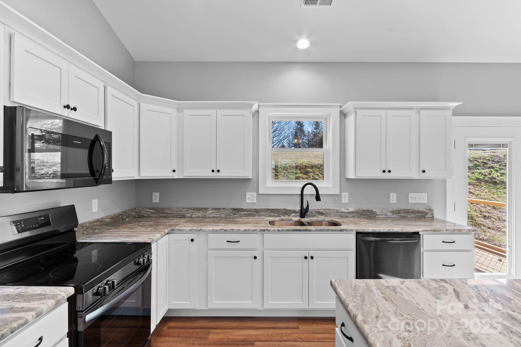 80 Peyton Elaine Road Clyde, NC 28721 - Photo 7 of 28 a kitchen with granite countertop a sink a stove and cabinets