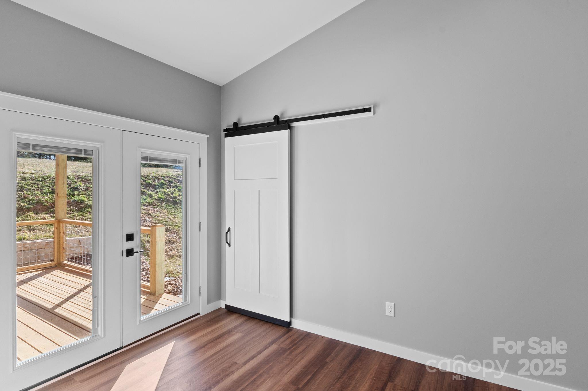 80 Peyton Elaine Road Clyde, NC 28721 - Photo 9 of 28 a view of an empty room with wooden floor and a window