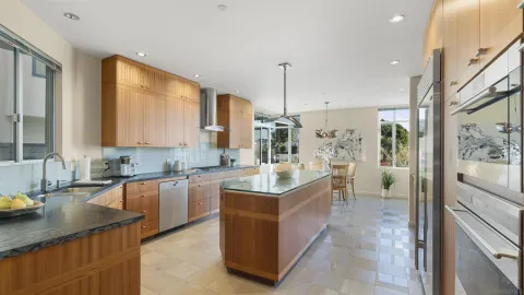 a kitchen with stainless steel appliances granite countertop a sink a stove and a refrigerator