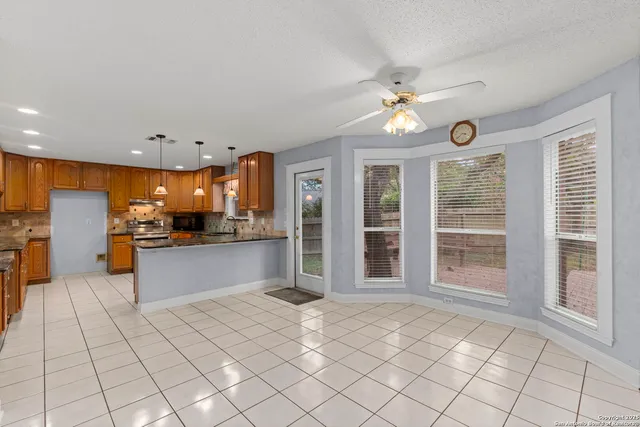 a large kitchen with stainless steel appliances granite countertop a refrigerator and a stove top oven