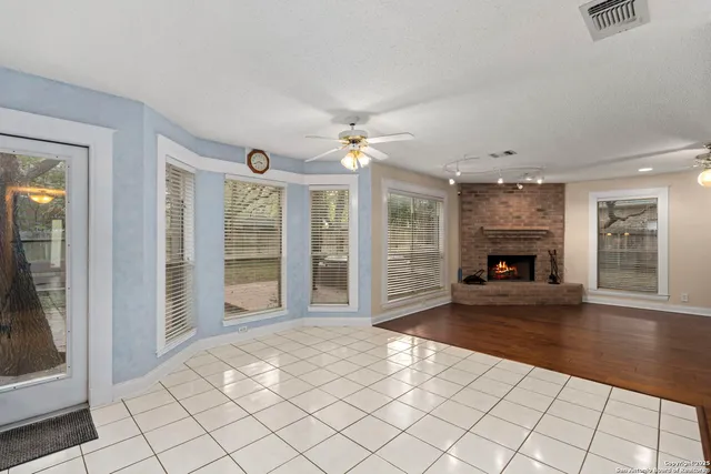 a view of an empty room with glass door and a fireplace