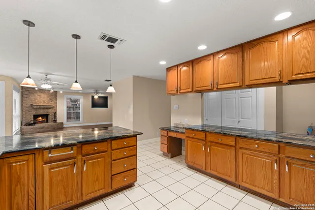 a kitchen with kitchen island granite countertop a sink a counter top space cabinets and stainless steel appliances