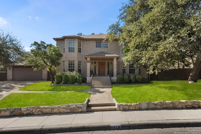 a front view of a house with a yard and potted plants