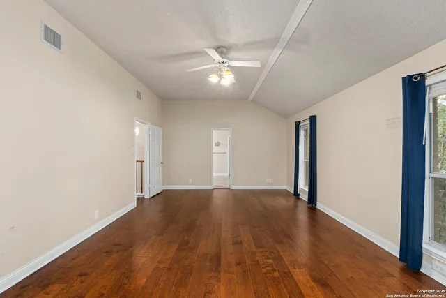 a view of an empty room with wooden floor