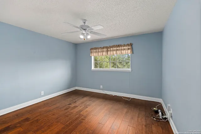 a view of an empty room with wooden floor