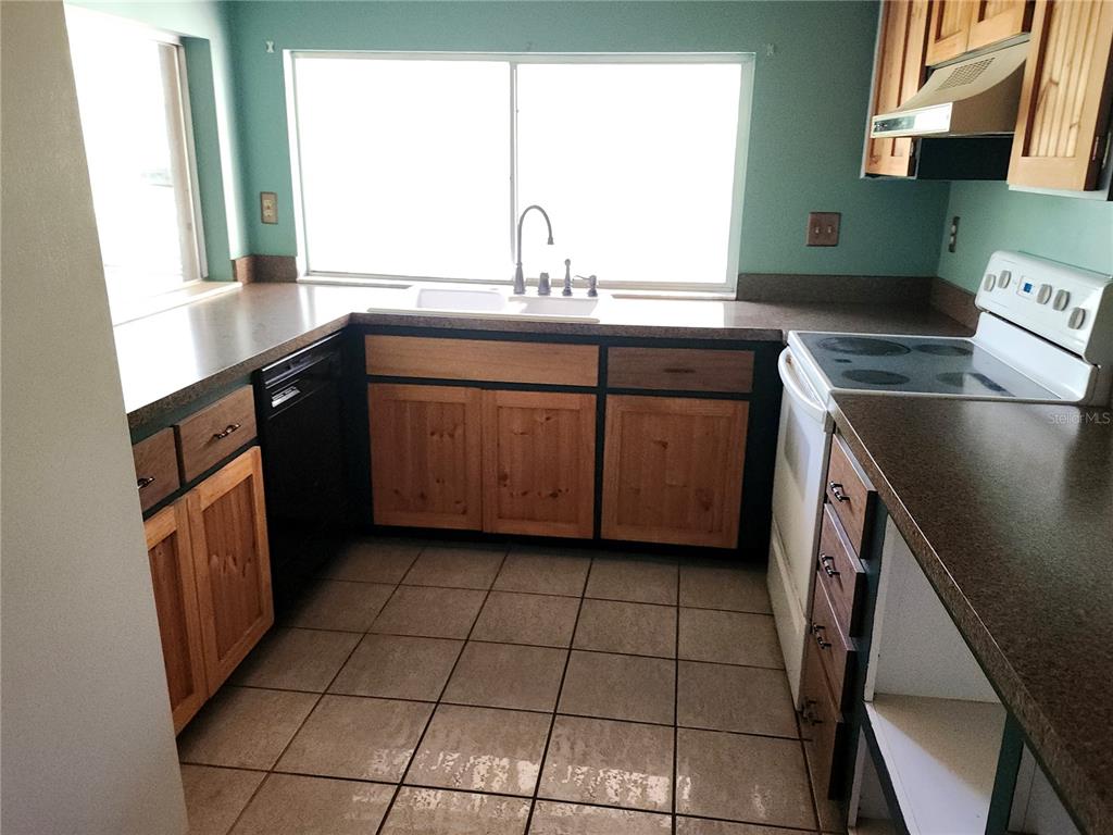 4060 Sail Drive New Port Richey, FL 34652 - Photo 6 of 20 a kitchen with a sink a stove cabinets and a window