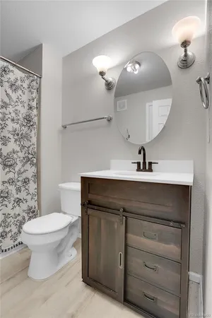 a bathroom with a sink a toilet and a mirror
