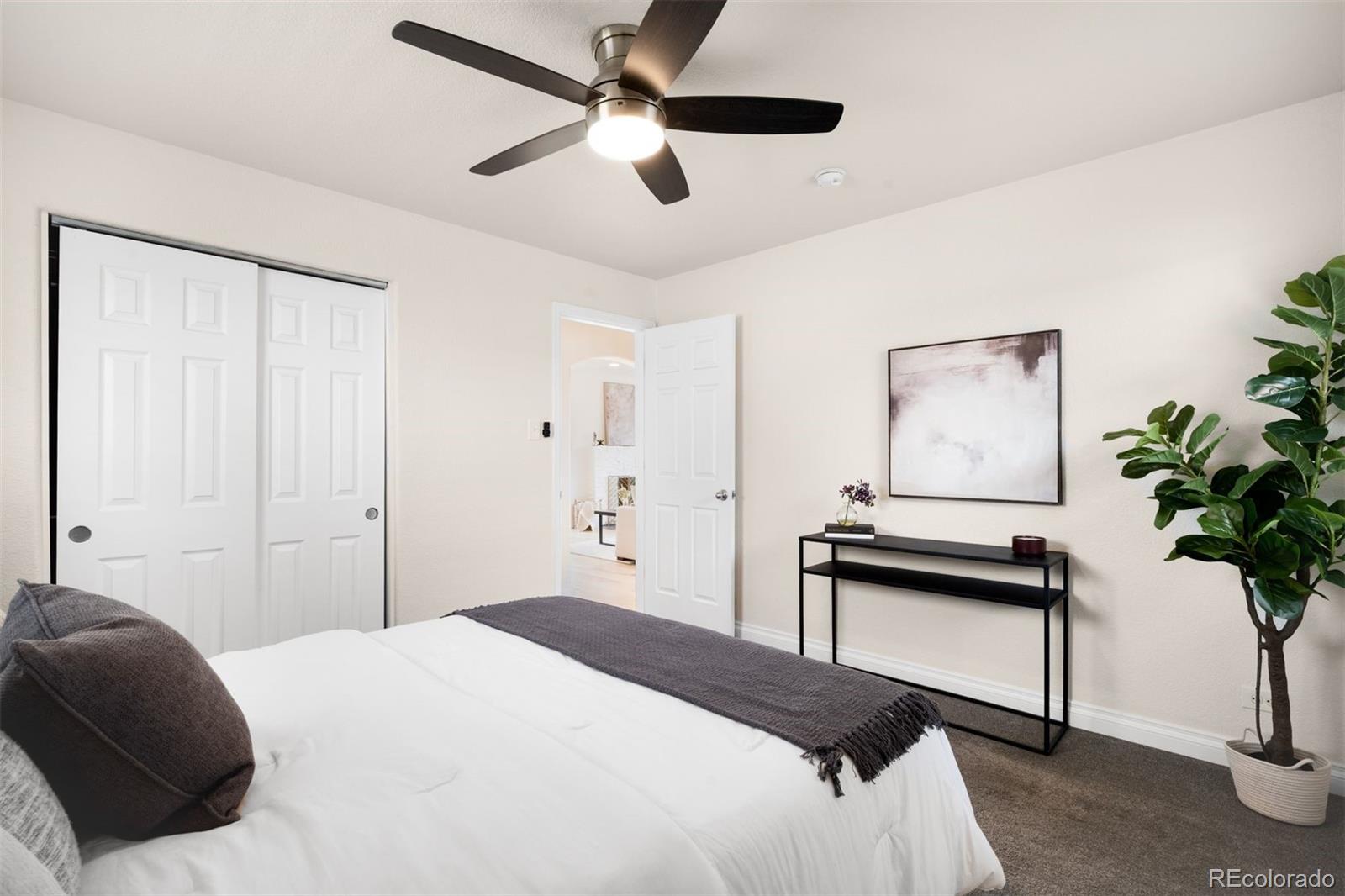 3000 Ivy Street Denver, CO 80207 - Photo 12 of 26 a bedroom with a bed and a potted plant