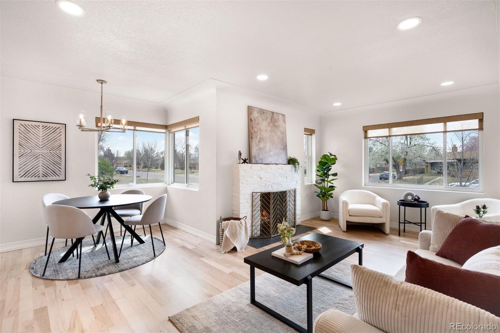 3000 Ivy Street Denver, CO 80207 - Photo 5 of 26 a living room with furniture a fireplace and a table with wooden floor