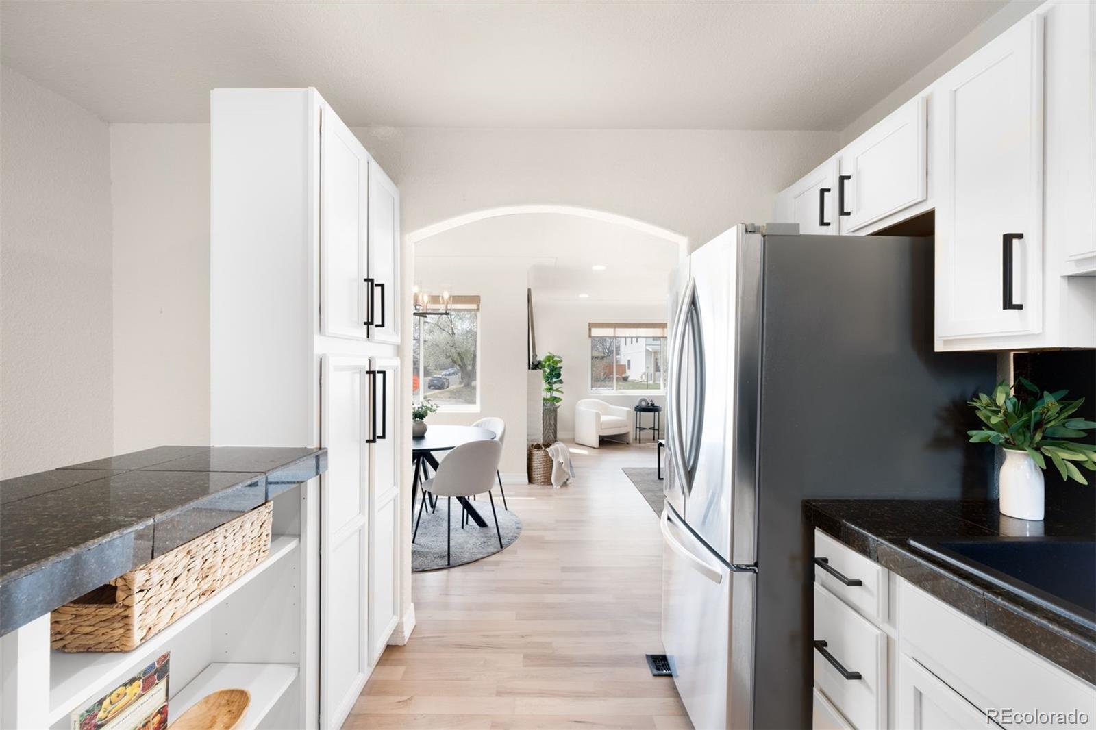 3000 Ivy Street Denver, CO 80207 - Photo 10 of 26 a kitchen with stainless steel appliances granite countertop a refrigerator and a counter space