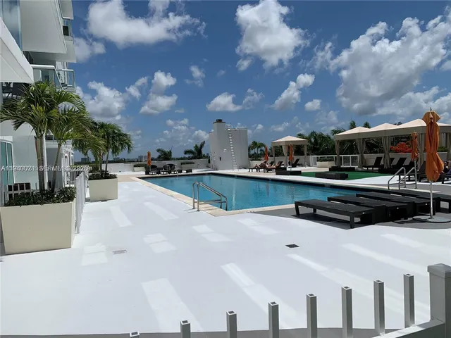 a swimming pool with outdoor seating and barbeque oven