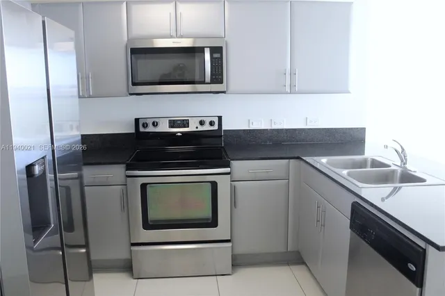 a kitchen with stainless steel appliances granite countertop a stove microwave and sink