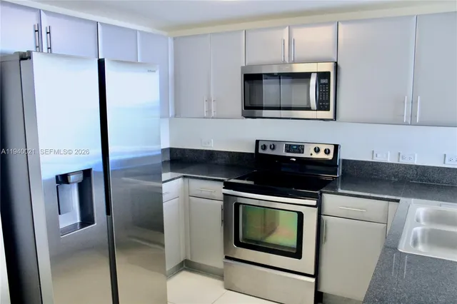 a kitchen with stainless steel appliances a stove a microwave and a refrigerator