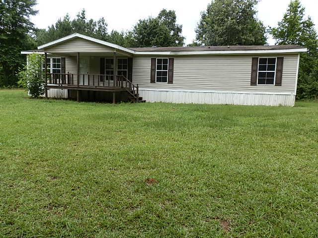 3080 Farmington Road Madison, GA 30650 - Photo 1 of 1 a front view of a house with a garden and yard