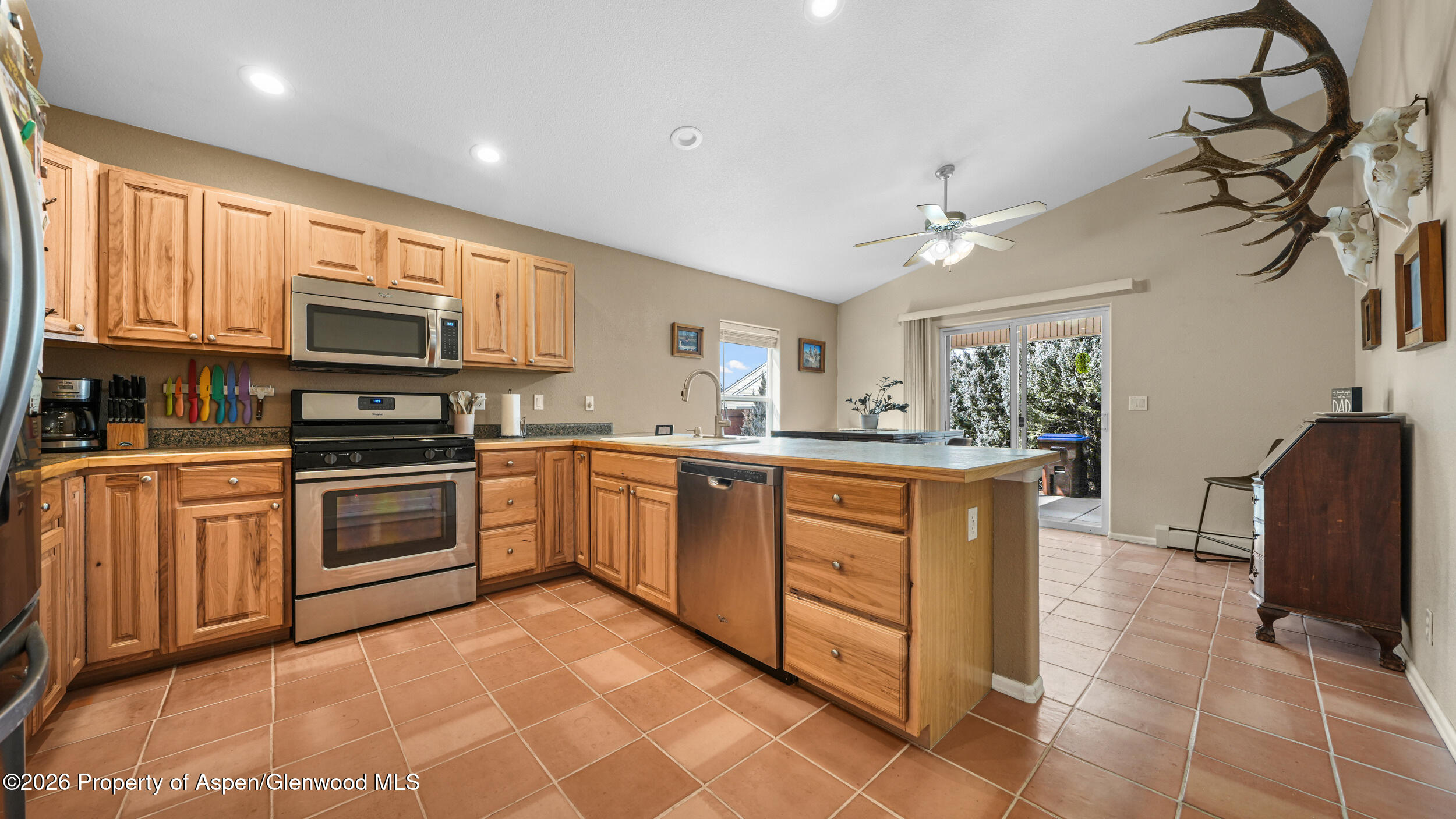 2703 Acacia Court Rifle, CO 81650 - Photo 10 of 29 a kitchen with stainless steel appliances granite countertop a stove top oven a sink dishwasher a dining table and chairs with wooden floor