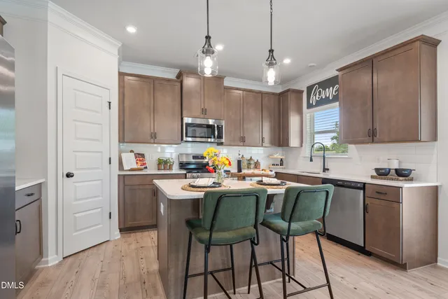 a kitchen with kitchen island white cabinets stainless steel appliances and a center island