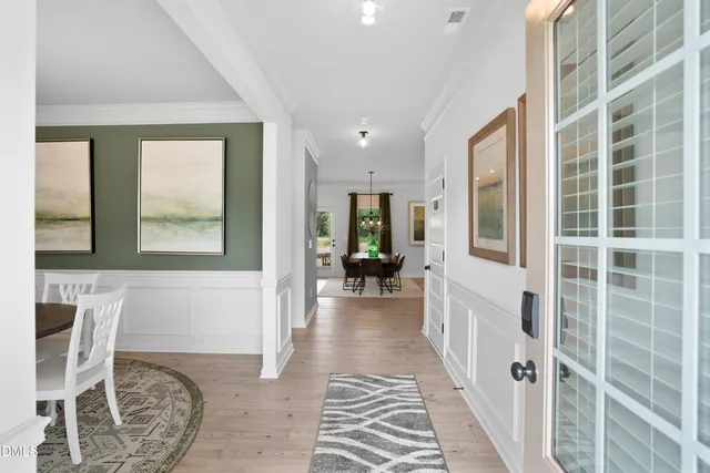 a view of a hallway with wooden floor and windows