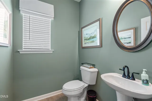 a bathroom with a toilet a sink and a mirror