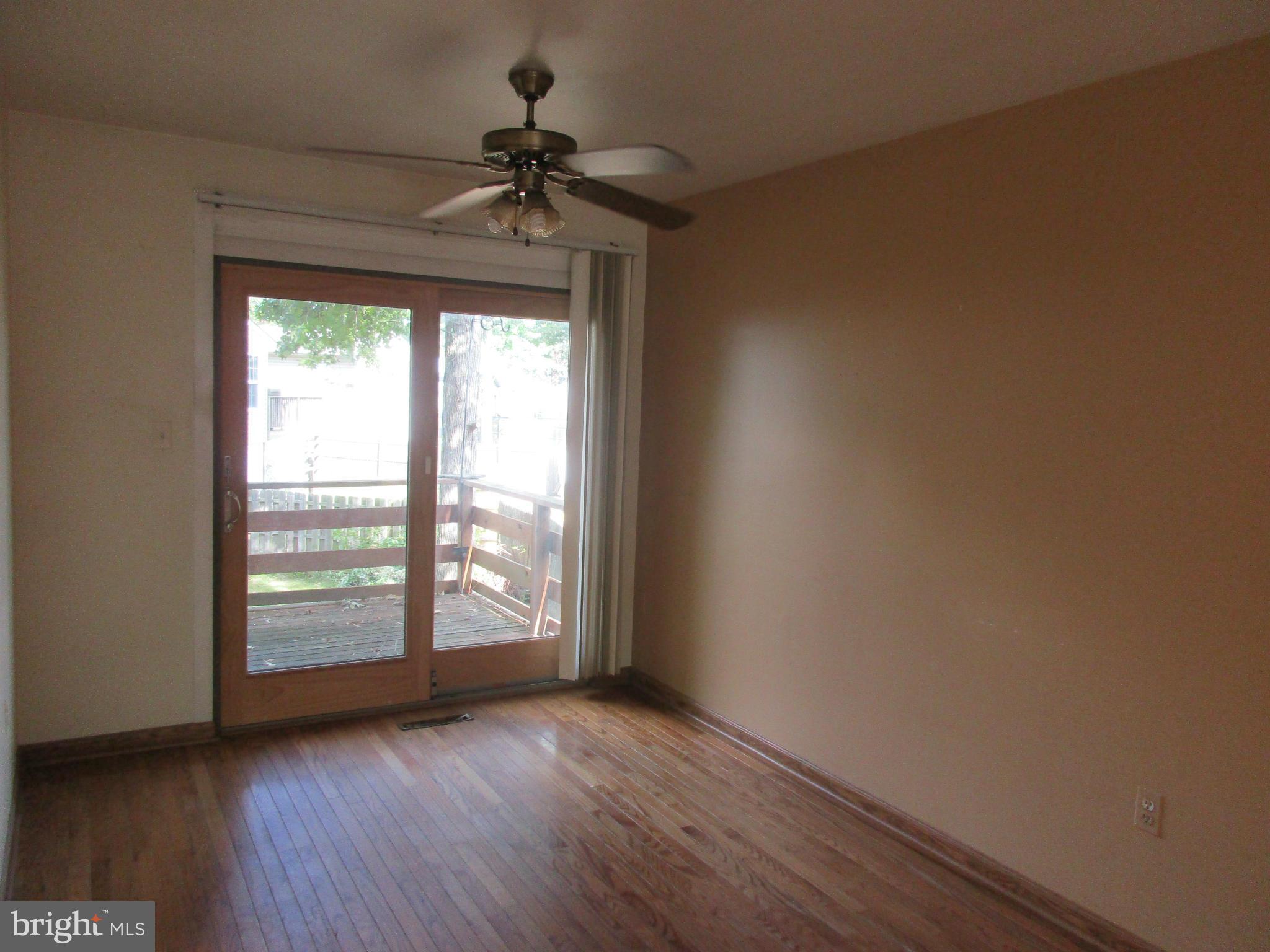 1635 Bay Ridge Road Edgewater, MD 21037 - Photo 3 of 15 an empty room with wooden floor fan and windows