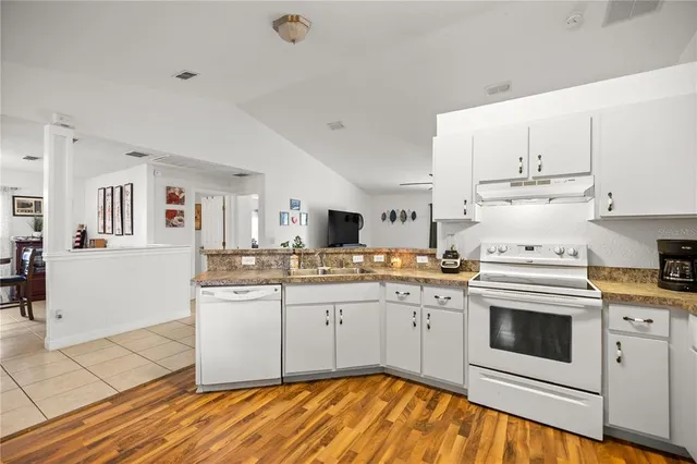 a kitchen with stainless steel appliances granite countertop a stove and white cabinets