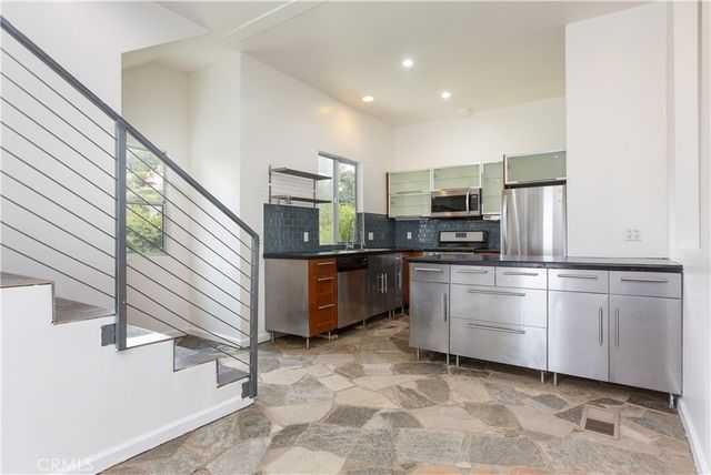 a kitchen with stainless steel appliances a refrigerator sink and microwave