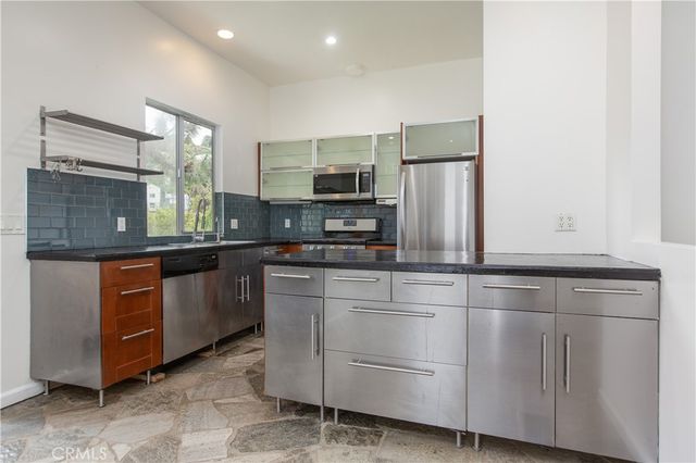 a kitchen with stainless steel appliances granite countertop a refrigerator and a stove