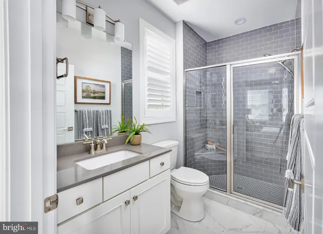 a bathroom with a shower sink vanity mirror and toilet