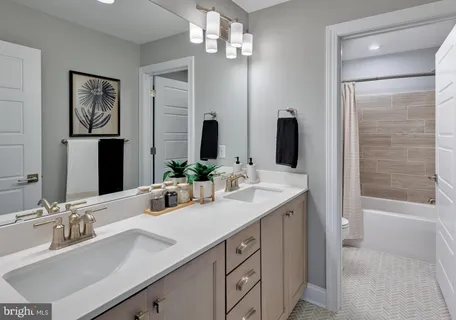 a bathroom with a double vanity sink a shower and a mirror