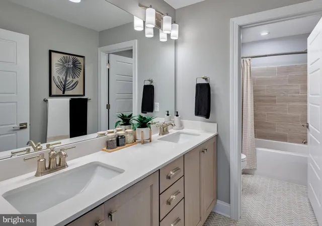a bathroom with a double vanity sink a shower and a mirror