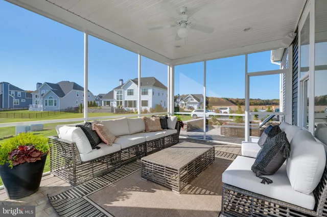 a living room with furniture a rug and a floor to ceiling window