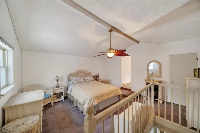 a bedroom with a bed ceiling fan and a window