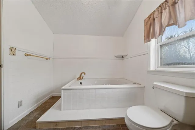 a bathroom with a tub a sink and a large mirror