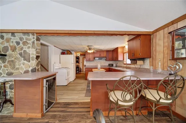 a kitchen with stainless steel appliances a center island cabinets and a chandelier