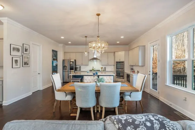 a kitchen with a dining table chairs stainless steel appliances and cabinets