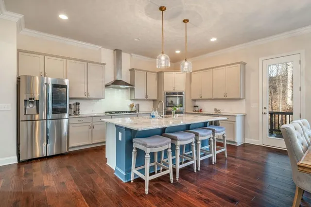 a view of a hallway with wooden floor and a bathroom