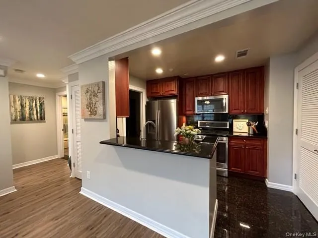 a kitchen with stainless steel appliances granite countertop a refrigerator stove top oven and sink