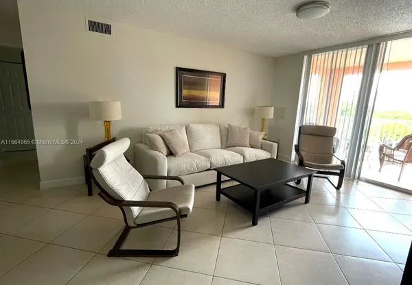 a living room with furniture and a floor to ceiling window