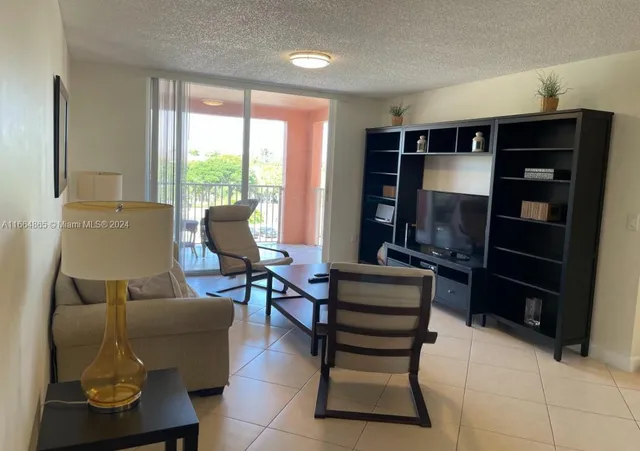 a living room with furniture a lamp and large window