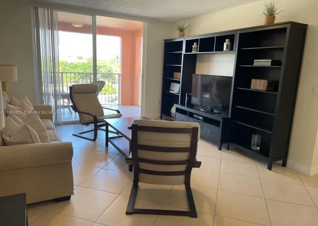 a living room with furniture a flat screen tv and a window