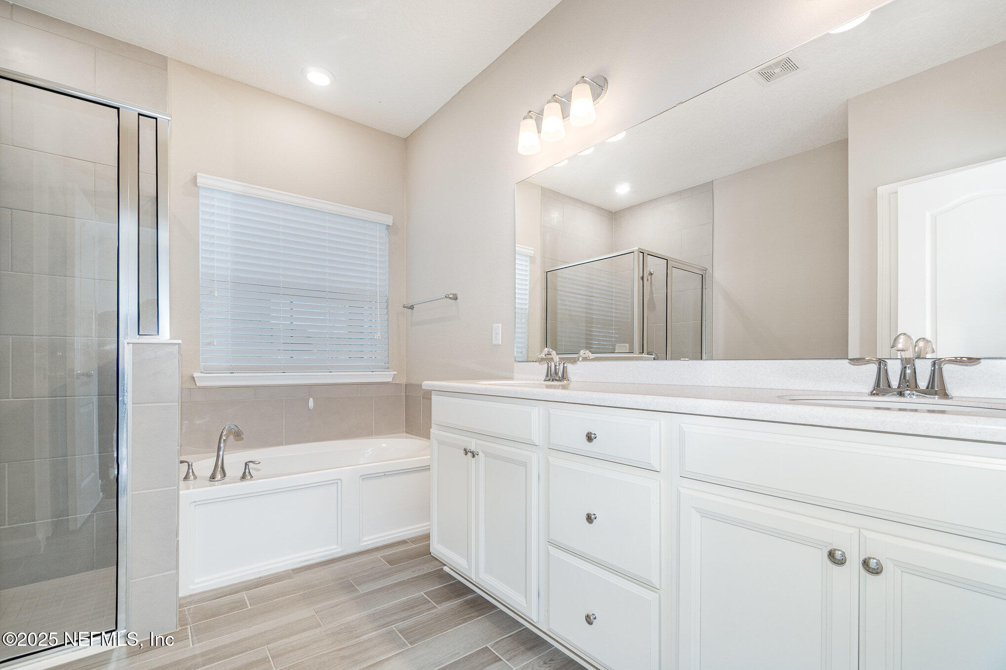 4220 Arbor Mill Circle Orange Park, FL 32065 - Photo 14 of 23 a bathroom with a bathtub a double vanity sink and mirror