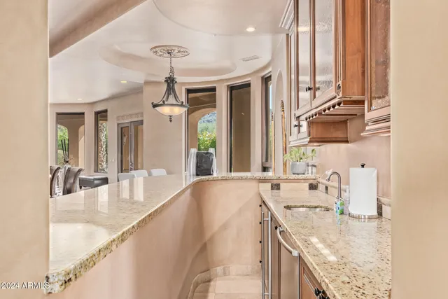 a spacious bedroom with a bed a chandelier and a couch