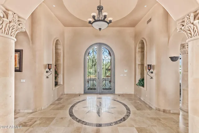 a bedroom with a bed a couch and chandelier