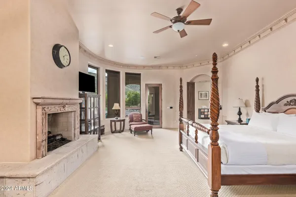 a spacious bedroom with a bed and a flat screen tv