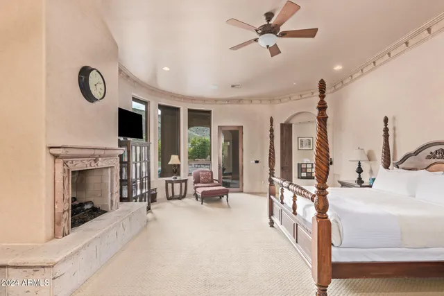 a spacious bedroom with a bed and a flat screen tv