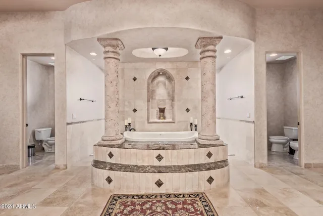 a spacious bedroom with a bed couch and a large window