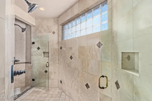 a spacious bedroom with a large bed and a chandelier